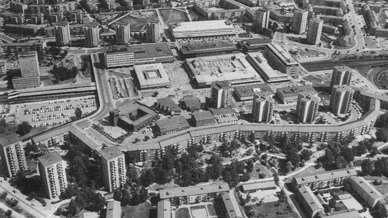 Luftaufnahme einer Siedlung mit vielen Hochhäusern und Wohnblöcken, die die Idee der autogerechten Stadt widerspiegelt.