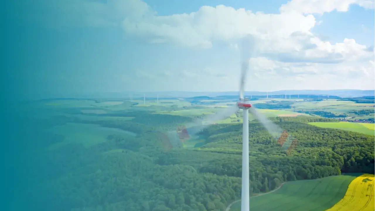 Windkraftanlage im Vordergrund, die sich dreht. Im Hintergrund eine Landschaft mit weiteren Anlagen, die die Amortisation der Windkraftanlage symbolisieren.