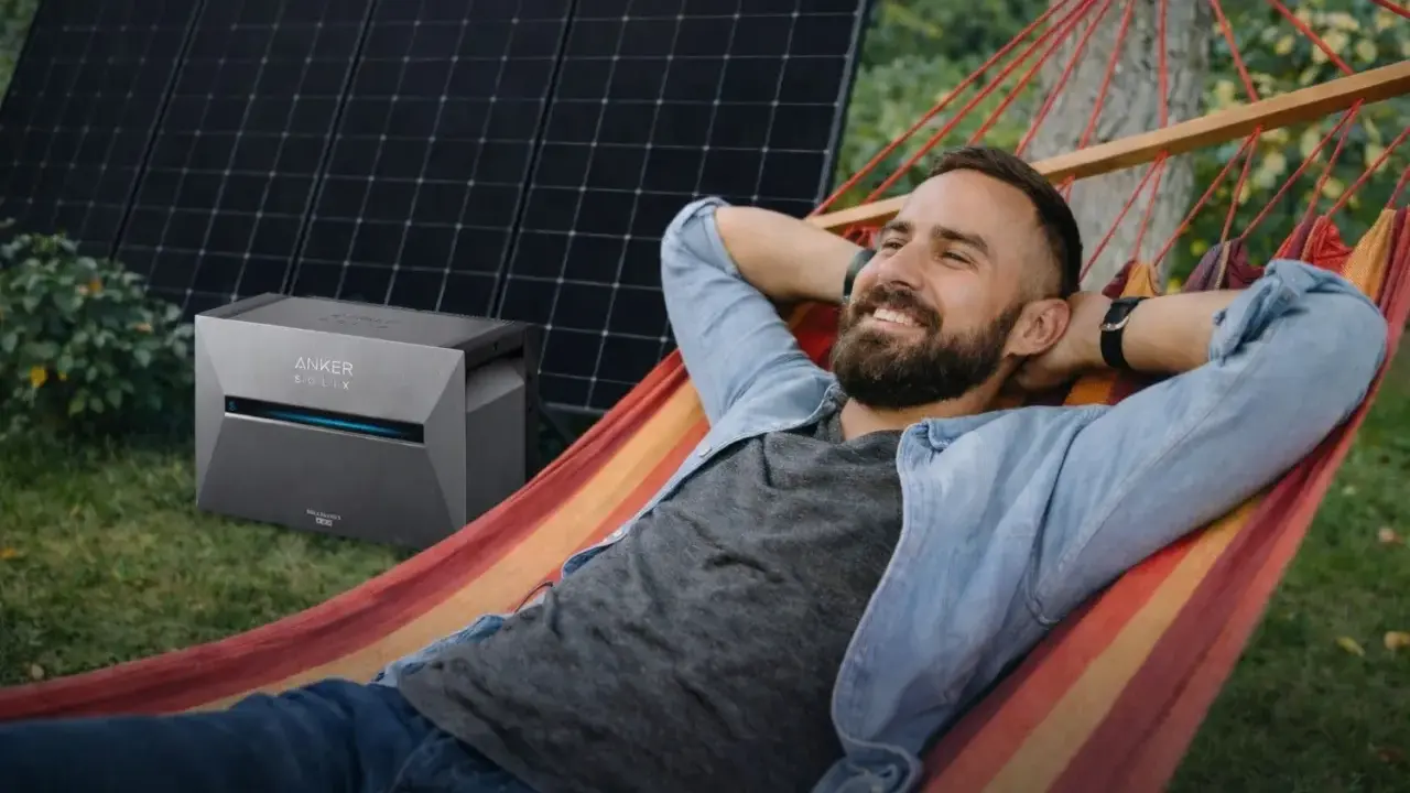 Mann entspannt in Hängematte, daneben Balkonkraftwerk Niedersachsen mit Solarmodulen.