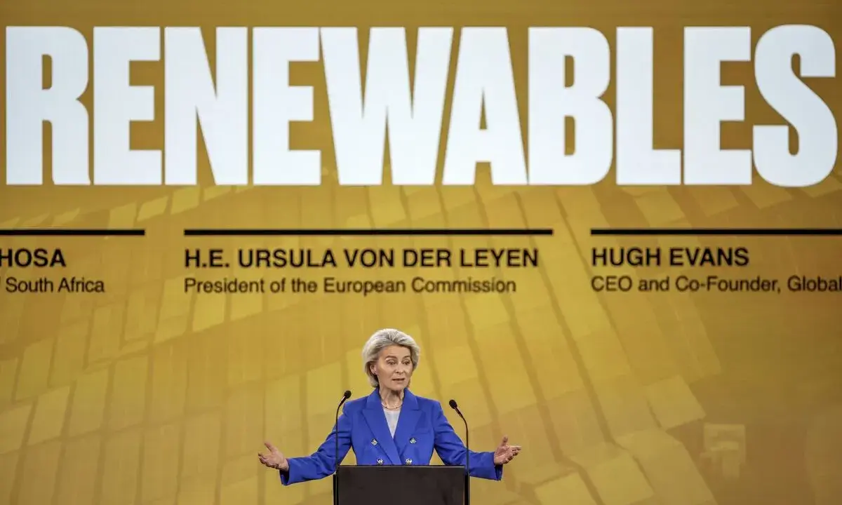 Ursula von der Leyen spricht über erneuerbare Energien. Ein Vergleich der europäischen Initiativen ist im Hintergrund zu sehen.