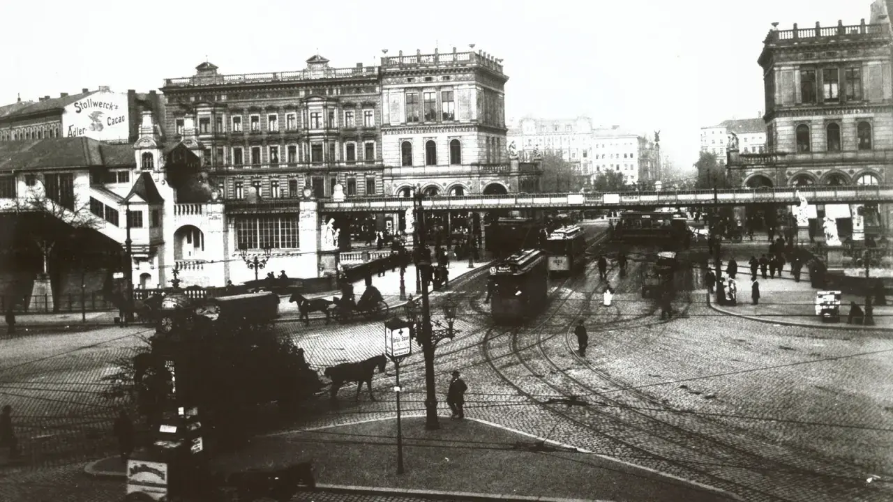 Straßenbahn und Pferdegespanne beleben eine geschäftige Stadtkreuzung, ein Zeichen für den wachsenden urbanisierungsgrad deutschland.