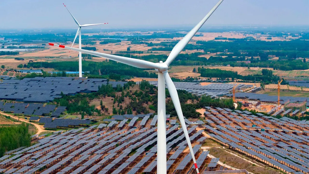 Große Windturbinen und weite Felder von Solarmodulen zeigen Chinas Engagement für erneuerbare Energien.