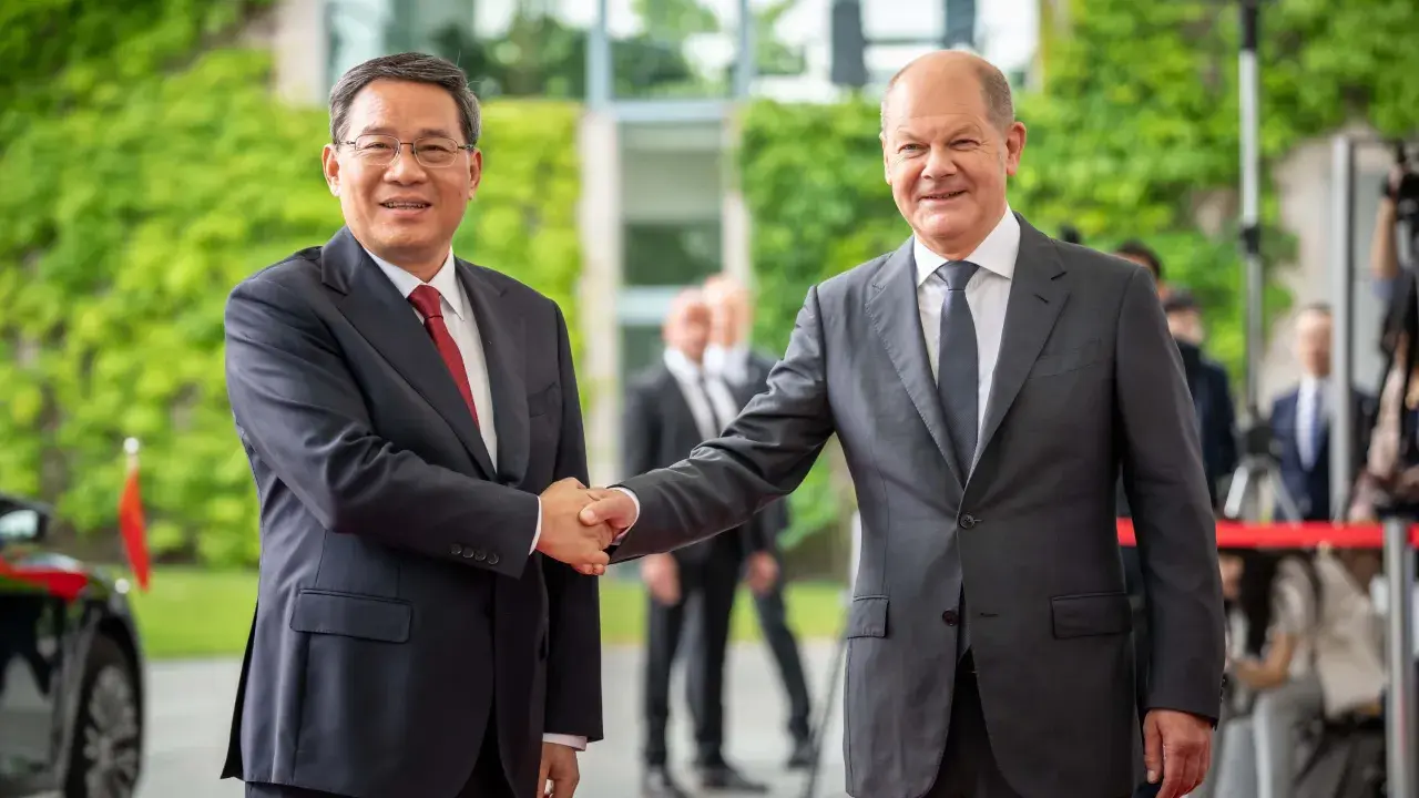 Zwei Männer schütteln sich die Hände. Im Hintergrund grüne Pflanzen und Gebäude. Ein Treffen, das die Weichen für eine gemeinsame Zukunft in Sachen China Nachhaltigkeit stellen könnte.
