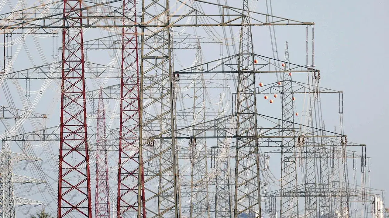 Hohe Strommasten, die Stromleitungen tragen, symbolisieren den Strom-Import und -Export Deutschlands.