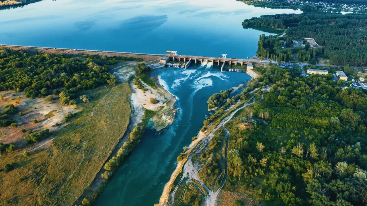 Luftaufnahme eines Laufwasserkraftwerks, das die Vorteile erneuerbarer Energie zeigt.