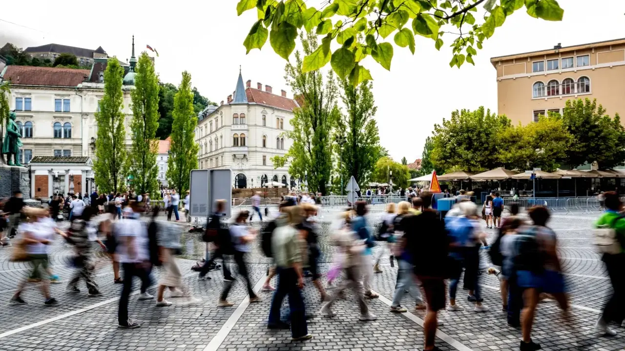 Menschen beleben den Platz, ein Beispiel für eine 15-Minuten-Stadt, die Bewegungsfreiheit und Gemeinschaft fördert.