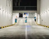 Einfahrt in eine Tiefgarage mit Schranken und Pfeilen, die den Weg weisen. Effizientes Parkraummanagement sorgt für Ordnung.