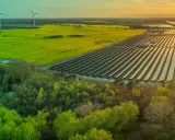 Weite Landschaft mit Windrädern, Solarpanels und grünen Feldern. Ein Zeichen für gesellschaftliche Akzeptanz erneuerbarer Energien.