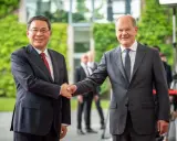 Zwei Männer schütteln sich die Hände. Im Hintergrund grüne Pflanzen und Gebäude. Ein Treffen, das die Weichen für eine gemeinsame Zukunft in Sachen China Nachhaltigkeit stellen könnte.
