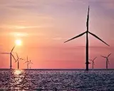 Windräder im Meer bei Sonnenuntergang. Ein Symbol für die EEG Umlage Befreiung und eine saubere Zukunft.