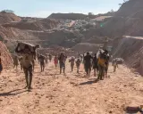 Kinder tragen schwere Säcke im Lithium-Abbau. Die harte Arbeit im Steinbruch zeigt die Realität von Kinderarbeit.