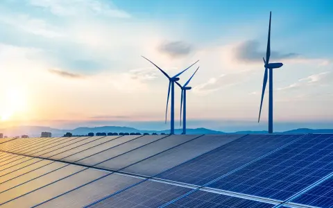 Solarpanels und Windräder im Sonnenuntergang symbolisieren die Versorgungssicherheit durch erneuerbare Energien.