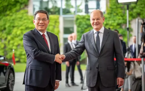 Zwei Männer schütteln sich die Hände. Im Hintergrund grüne Pflanzen und Gebäude. Ein Treffen, das die Weichen für eine gemeinsame Zukunft in Sachen China Nachhaltigkeit stellen könnte.