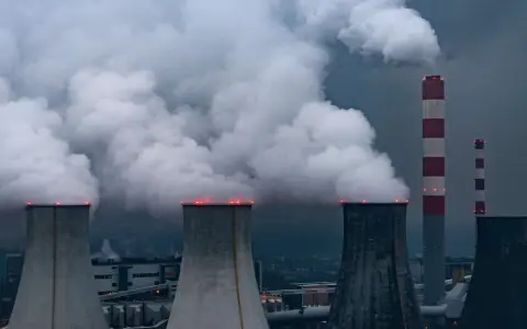 Rauchschwaden steigen aus Kühltürmen und Schornsteinen von Kohlekraftwerken in Polen auf, ein düsteres Bild der Energieerzeugung.