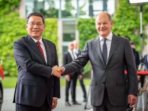 Zwei Männer schütteln sich die Hände. Im Hintergrund grüne Pflanzen und Gebäude. Ein Treffen, das die Weichen für eine gemeinsame Zukunft in Sachen China Nachhaltigkeit stellen könnte.