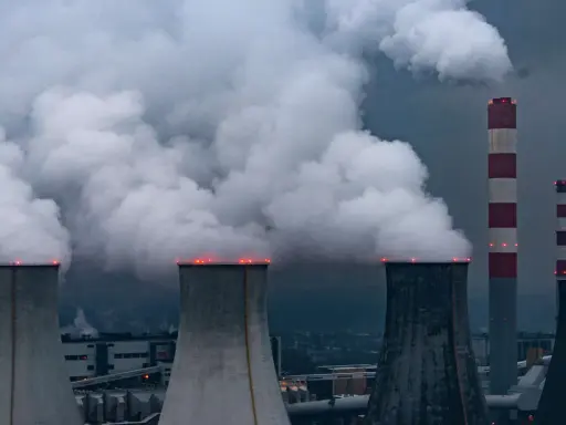 Rauchschwaden steigen aus Kühltürmen und Schornsteinen von Kohlekraftwerken in Polen auf, ein düsteres Bild der Energieerzeugung.