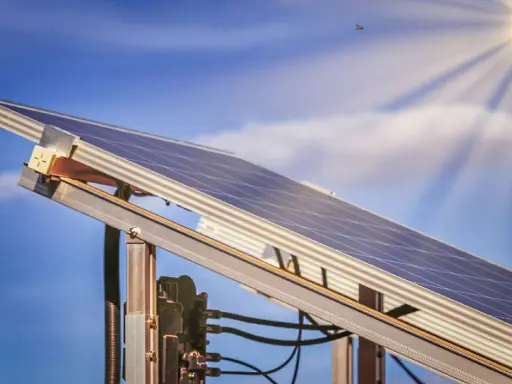 Ein Balkonkraftwerk MV fängt die Sonnenstrahlen ein. Der blaue Himmel mit Wolken und die Sonne im Hintergrund versprechen viel Energie.