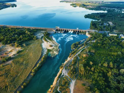 Luftaufnahme eines Laufwasserkraftwerks, das die Vorteile erneuerbarer Energie zeigt.