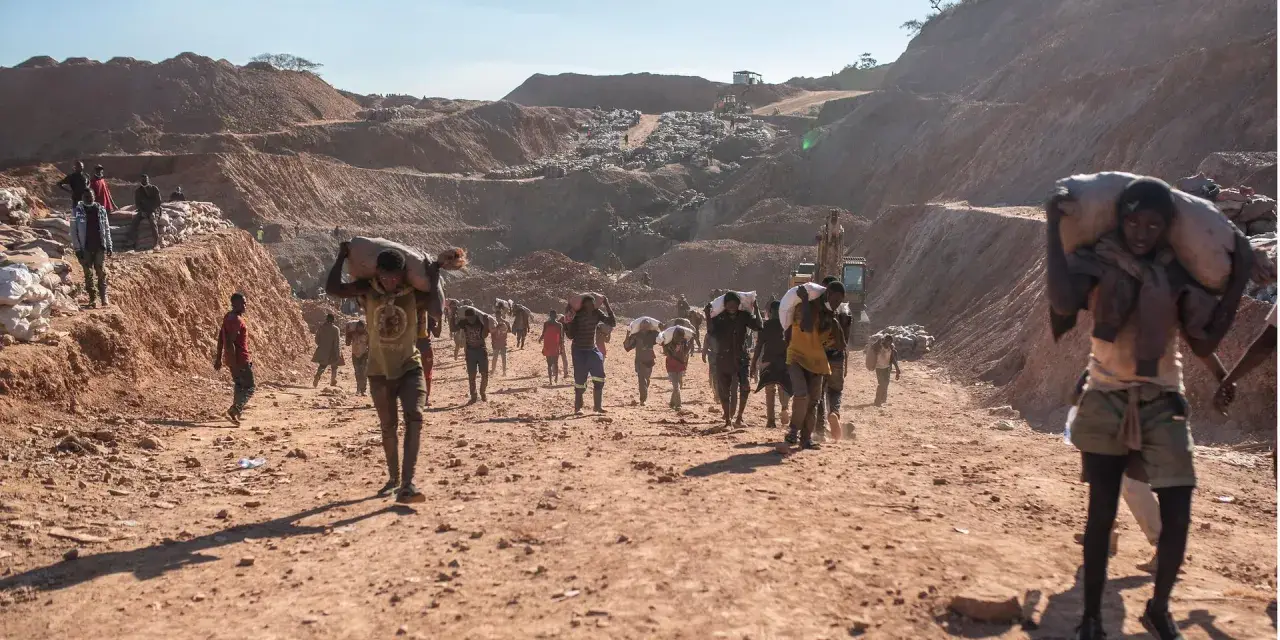 Kinder tragen schwere Säcke im Lithium-Abbau. Die harte Arbeit im Steinbruch zeigt die Realität von Kinderarbeit.