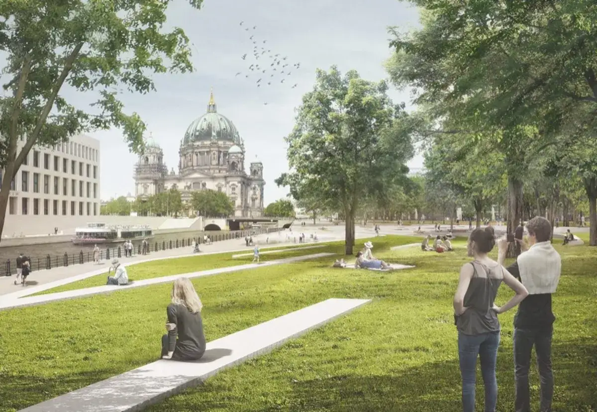 Grüne Uferpromenade mit Menschen, die sich entspannen. Im Hintergrund der Berliner Dom und moderne Gebäude. Eine gegliederte und aufgelockerte Stadt mit viel Grün.
