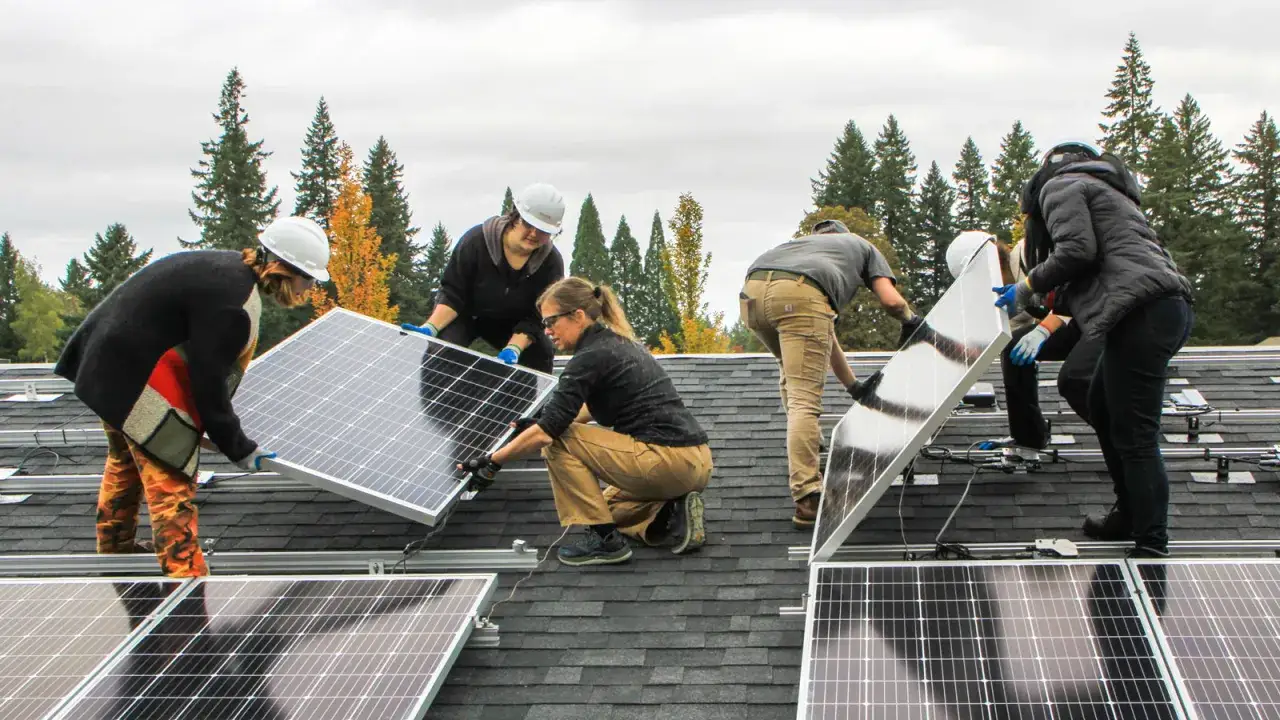 Team installiert Solarmodule auf einem Dach. Ein Beispiel für zukunftsorientierte energie jobs.