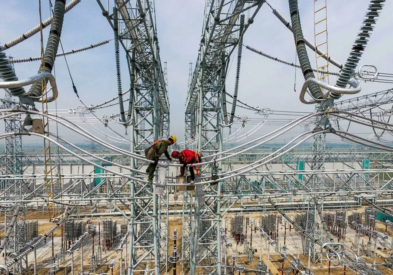 Arbeiter sichern die Energieversorgung Chinas auf einer Hochspannungsanlage.