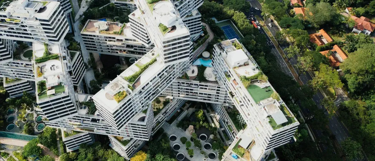 Moderne Architektur mit begrünten Dächern und Innenhöfen, die eine nachhaltige Stadt verkörpert. Ein Pool und Tennisplatz sind sichtbar.