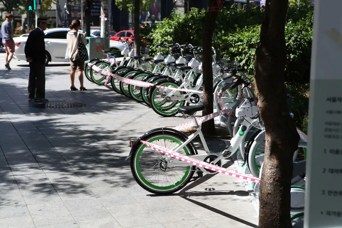 Reihe von wei&szlig;en Leihr&auml;dern mit gr&uuml;nen Felgen, bereit f&uuml;r das sharing city Seoul.