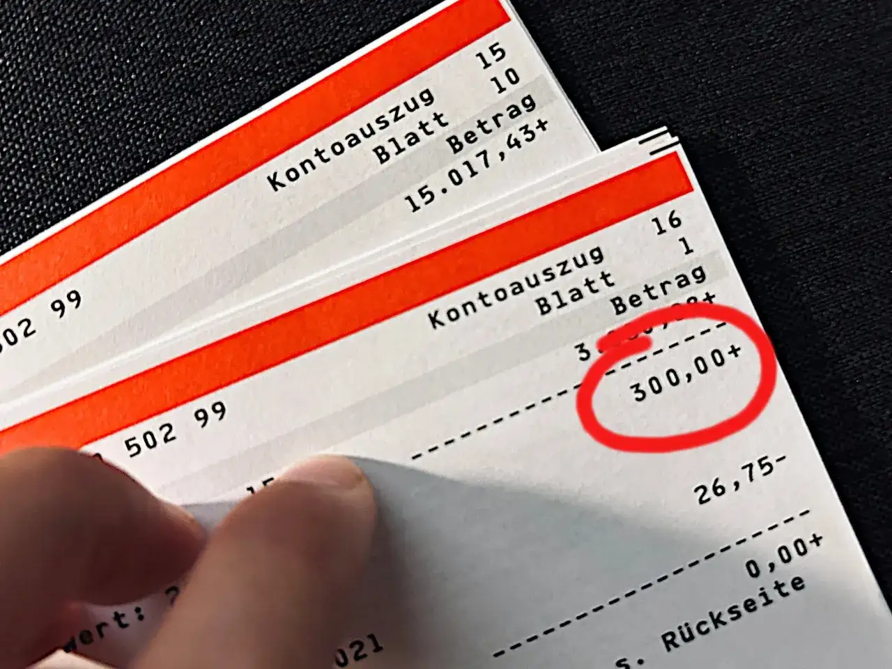 Kontoauszüge zeigen, wie das klima geld fließt. Ein Betrag von 300,00+ ist rot eingekreist.