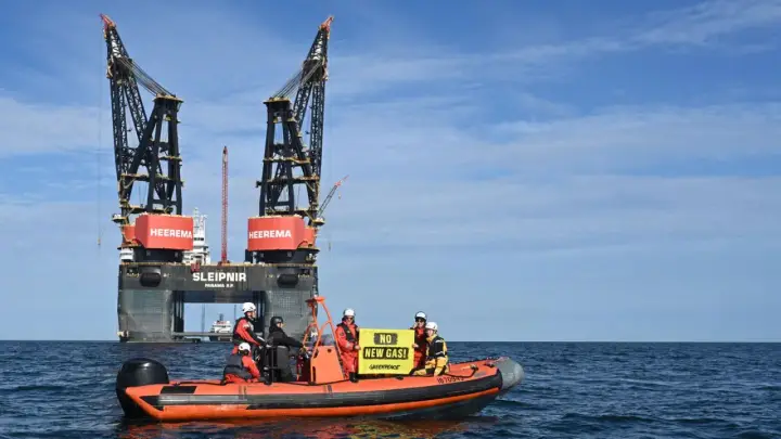 A Greenpeace-Boot protestiert gegen die Gasförderung vor Borkum. Auf dem Boot halten Aktivisten ein Banner mit der Aufschrift "NO NEW GAS!".